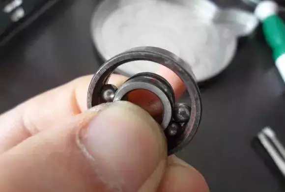 用手將軸承拿起，需要注意要向有滾珠的方向頂住